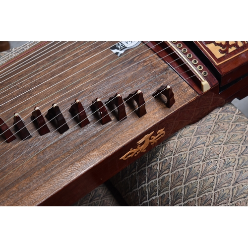 313 - A Chinese Guzheng or zither, made in the traditional form, with hard wood base, fretwork compartment... 