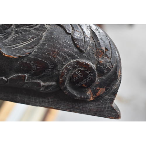 215 - A 19th century carved oak pediment, carved with griffins and fruit, 99cm wide.