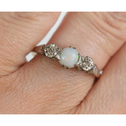 127 - A 9ct gold and platinum dress ring set with central opal with illusion set old cut diamonds either s... 