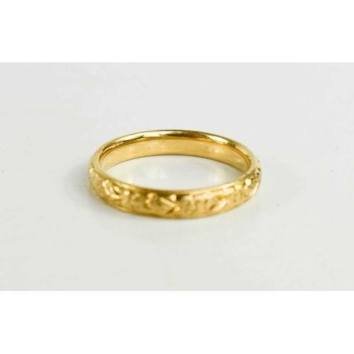 148 - An 18ct gold wedding band, foliate engraved, size K, 3.1g.