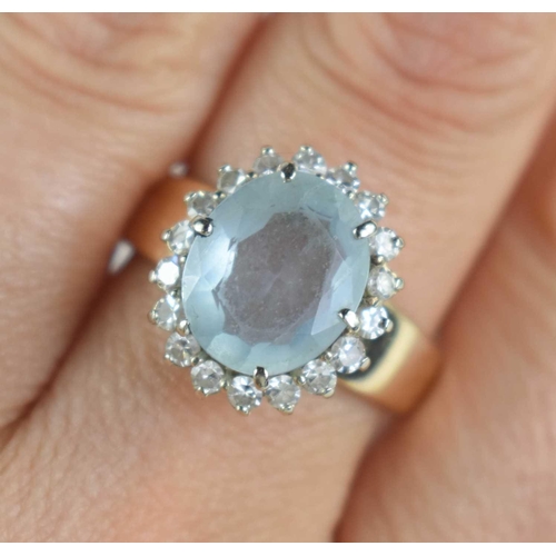 165 - A 14ct gold, aquamarine and diamond dress ring, the oval cut stone of approximately 12 by 10mm surro... 