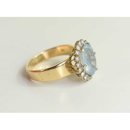 165 - A 14ct gold, aquamarine and diamond dress ring, the oval cut stone of approximately 12 by 10mm surro... 