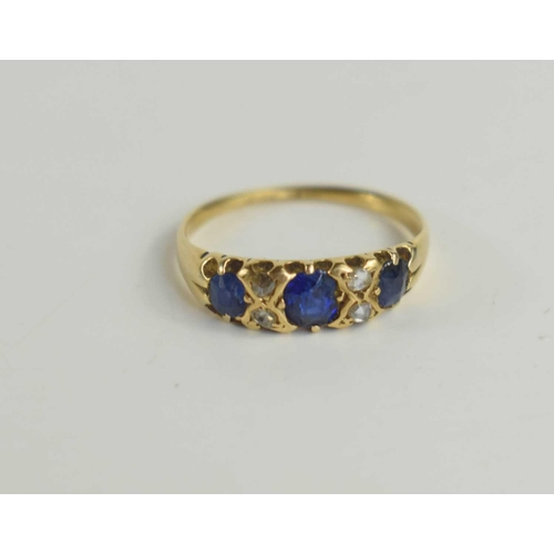 168 - An 18ct gold, sapphire and diamond ring, set with three cornflower blue sapphires interspersed with ... 
