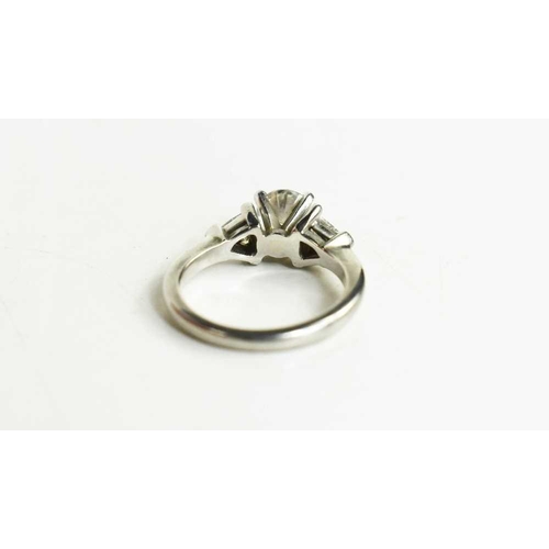 221 - A platinum and diamond ring, composed of a central brilliant cut 1ct diamond, VS1, colour E, flanked... 