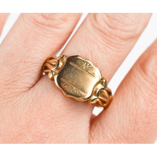 223 - A 9ct gold signet ring, of shield form with scroll shoulders, size V, 7.8g.