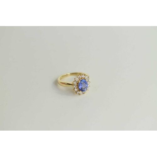 242 - A 14ct gold, tanzanite and diamond ring, the oval cut tanzanite of approximately 5.9 by 7.5mm, surro... 