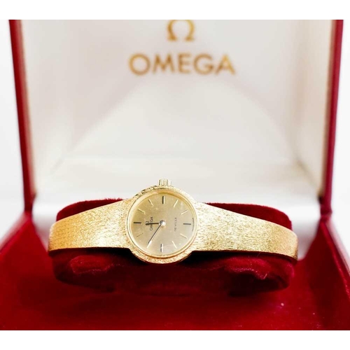 263 - An 18ct gold Omega ladies wristwatch, the circular dial with baton markers, and a 18ct gold bark eff... 