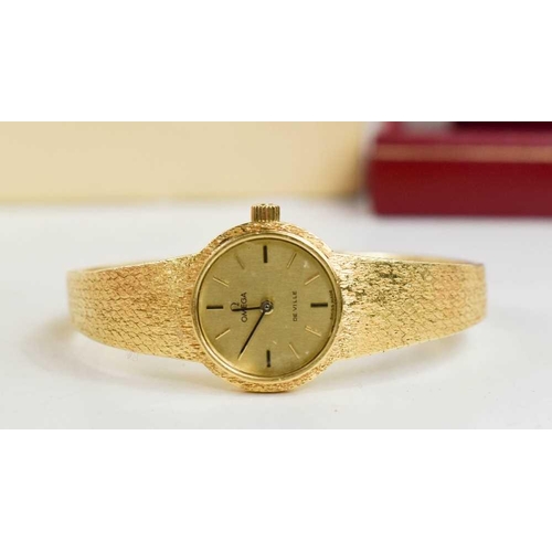 263 - An 18ct gold Omega ladies wristwatch, the circular dial with baton markers, and a 18ct gold bark eff... 