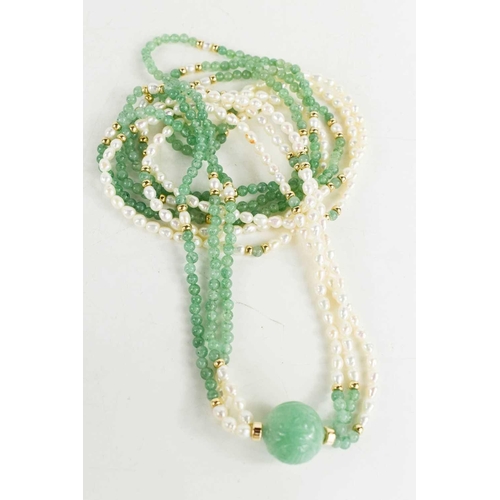 56 - A Chinese jade and pearl double strand necklace with carved ball pendant and gilt metal beads.