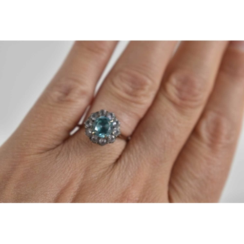 65 - A 9ct gold and paste cluster ring set with an aquamarine coloured central stone encircled with white... 