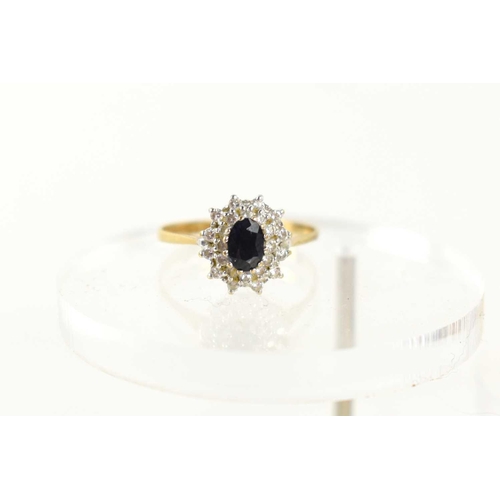 96 - A 9ct gold, sapphire and diamond cluster ring, the central oval sapphire of approximately 6.1 by 4.2... 