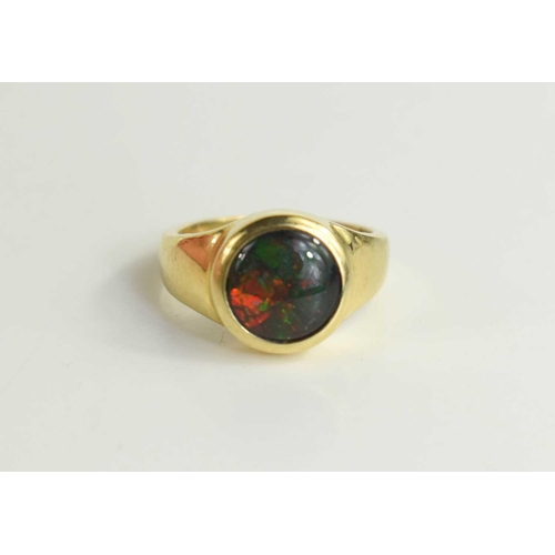99 - A 14ct gold and synthetic opal set ring, the black opalescent stone of mosaic crystal form, size N/O... 