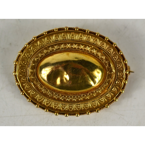 87 - A Victorian mourning brooch, of oval form with engraved decoration, glass back, total weight 8g.