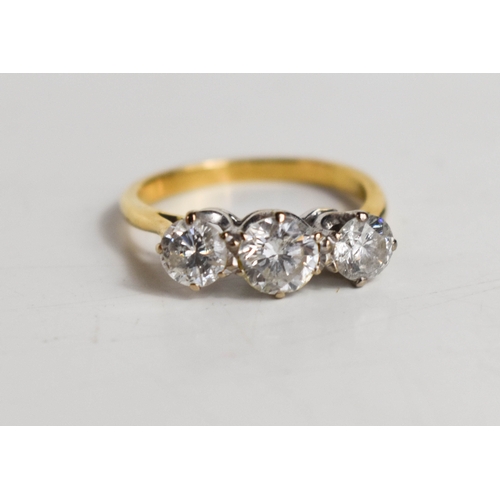 215A - A gold and diamond three stone ring, the central brilliant cut diamond approximately ½ct, flanked by... 