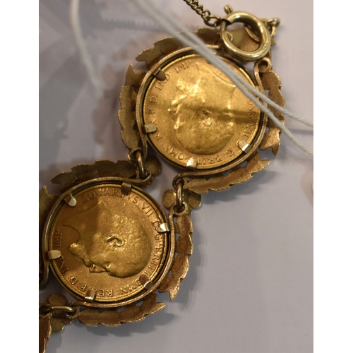 219 - A 9ct gold bracelet set with six half sovereigns, in a pretty laurel leaf and flowerhead setting to ... 