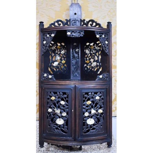 111 - A Chinese vintage hardwood corner cupboard, the back, corner brackets and bow front cupboard doors a... 