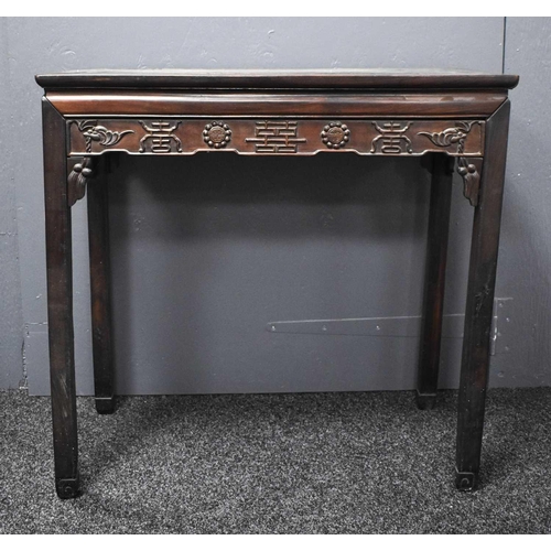 112 - A 19th century Chinese altar table, the shaped apron carved with various symbols, 86 by 90cm.