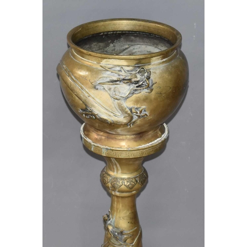 115 - A Japanese Meiji period brass jardiniere on stand modelled with dragons, 88.5cm high.