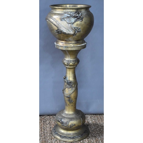 115 - A Japanese Meiji period brass jardiniere on stand modelled with dragons, 88.5cm high.