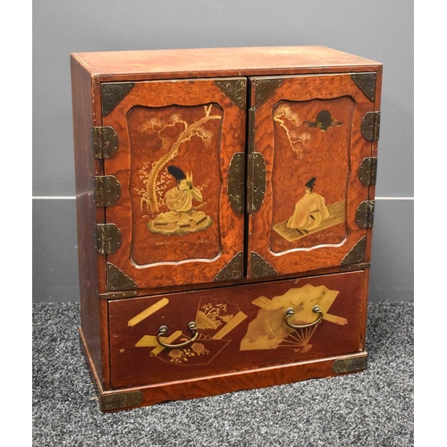 117 - A 19th century Japanese red lacquered table cabinet, the upper section having two cupboard doors, de... 