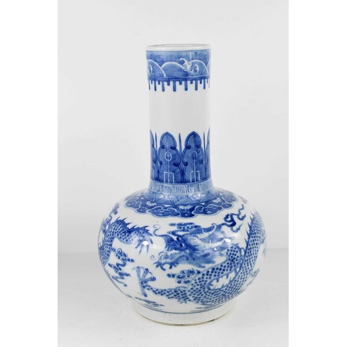 15 - A Chinese blue and white bottle vase, with tall stem, and ovoid body decorated with two wrythern dra... 