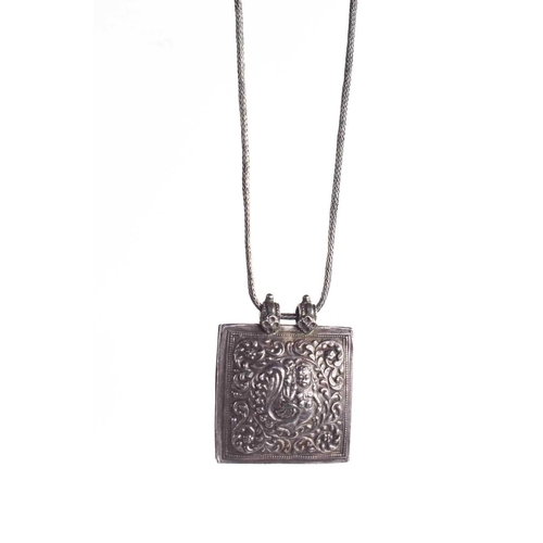 33 - An Indian white metal pendant necklace, the pendant embossed with a Kinnara; a mythical half bird-ha... 