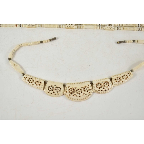 34 - A large carved bone five strand necklace, 73cm, together with a smaller bone necklace with carved fl... 