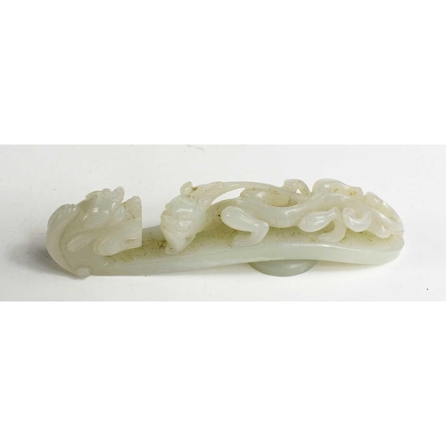 4 - A Chinese 19th century jade button / belt hook, the top in the form of a dragon head, 11.5cm long.