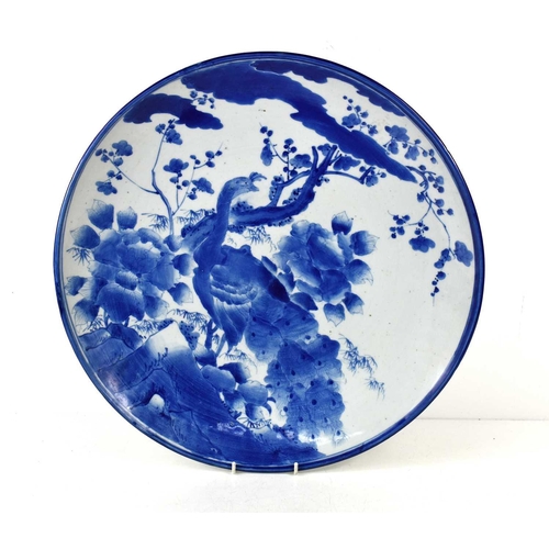 46 - An early 19th century Chinese blue and white porcelain charger, decorated with a peacock amongst fol... 