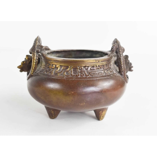 50 - A late 19th / early 20th century bronze miniature Chinese censor, cast with two dragon form handles,... 