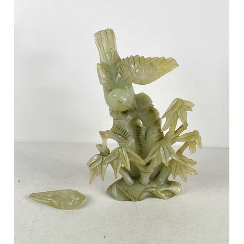 51 - A Chinese jade carving of a bird perched among foliage, 19cm high, a/f.