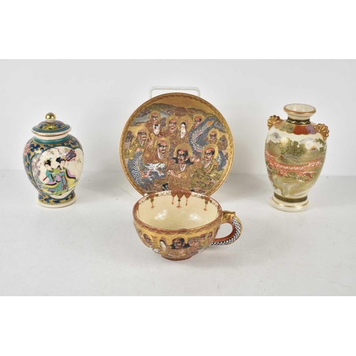 86 - A Japanese Satsuma cup and saucer decorated with a dragon and figures together with two small Japane... 