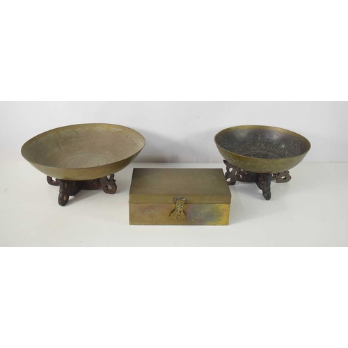 89 - Two Qing Dynasty brass bowls on wooden carved x-form stands, both decorated with foliate and calligr... 