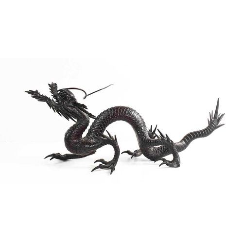 9 - A Qing Dynasty Chinese bronze dragon, of dark brown patination, cast with detailed scales and featur... 