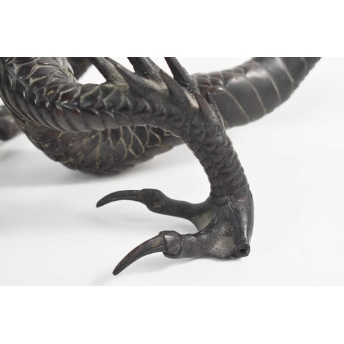 9 - A Qing Dynasty Chinese bronze dragon, of dark brown patination, cast with detailed scales and featur... 