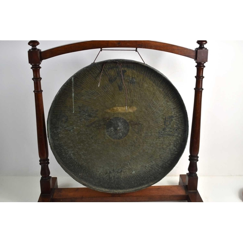 90 - A 19th century Chinese bronze dinner gong suspended in a turned mahogany frame, the hand beaten bron... 