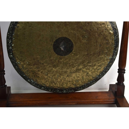 90 - A 19th century Chinese bronze dinner gong suspended in a turned mahogany frame, the hand beaten bron... 