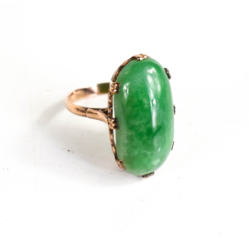 25A - A 9ct gold and jade ring, the oval cabochon jade in a double claw setting with hearts pierced to the... 