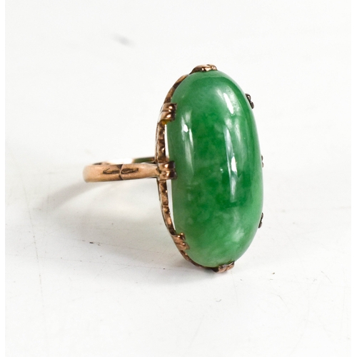 25A - A 9ct gold and jade ring, the oval cabochon jade in a double claw setting with hearts pierced to the... 