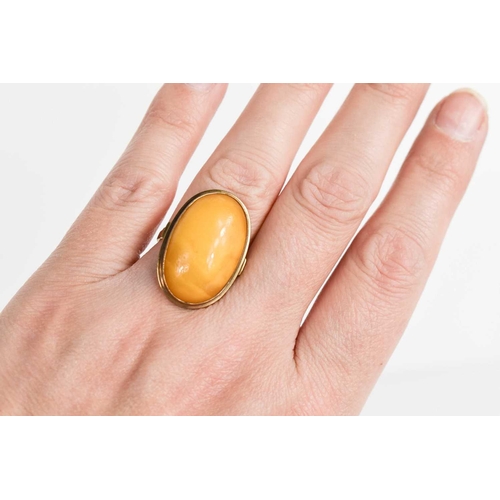 121 - An 8ct gold and butterscotch amber cabochon ring, marked 333 alongside maker AK, size K, 5.3g.