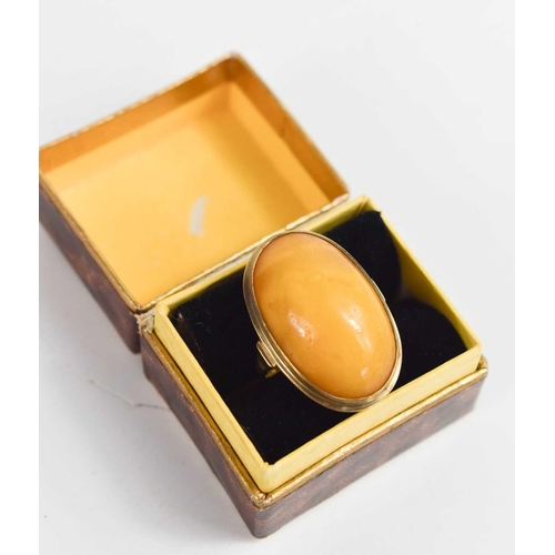 121 - An 8ct gold and butterscotch amber cabochon ring, marked 333 alongside maker AK, size K, 5.3g.