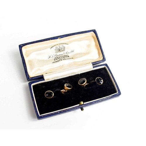 125 - A pair of 14ct gold and garnet set cufflinks, composed of two oval cut garnets with clip attaching t... 