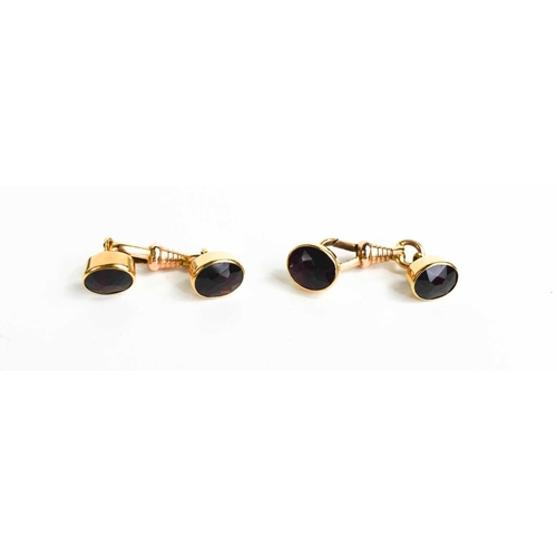 125 - A pair of 14ct gold and garnet set cufflinks, composed of two oval cut garnets with clip attaching t... 