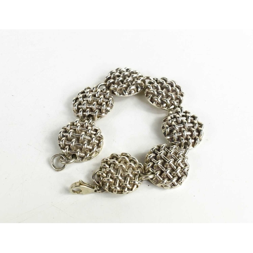 145 - A silver bracelet by Kate Naylor High, composed of seven circular links with weave pattern, 3.75g.