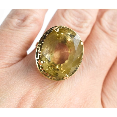 153 - An 18ct gold and pale citrine ring, the oval citrine in four claw setting, with a decorative pierced... 