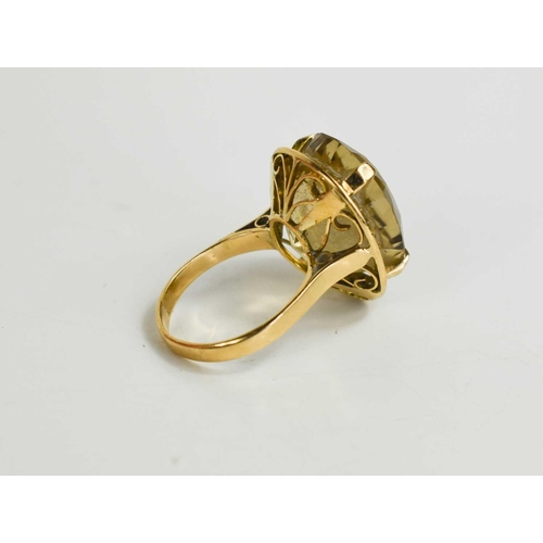 153 - An 18ct gold and pale citrine ring, the oval citrine in four claw setting, with a decorative pierced... 