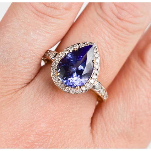 162 - An 18ct gold, tanzanite and diamond ring, the pear cut tanzanite bordered by brilliant cut diamonds,... 