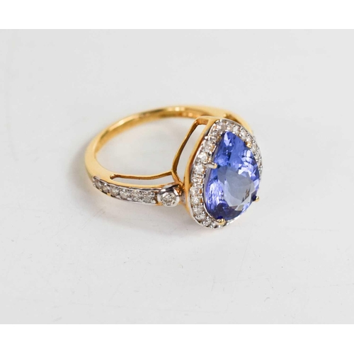 162 - An 18ct gold, tanzanite and diamond ring, the pear cut tanzanite bordered by brilliant cut diamonds,... 