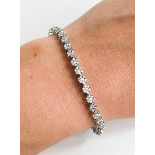 178 - An 18ct white gold and diamond tennis bracelet, each link comprising seven brilliant cut diamonds in... 