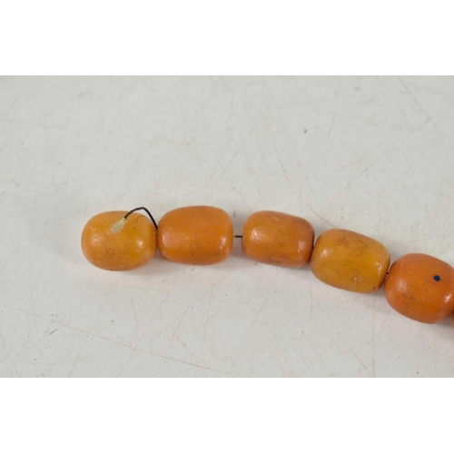 18 - A vintage butterscotch amber beaded necklace, composed of graduated beads on a wire string, 56g. one... 